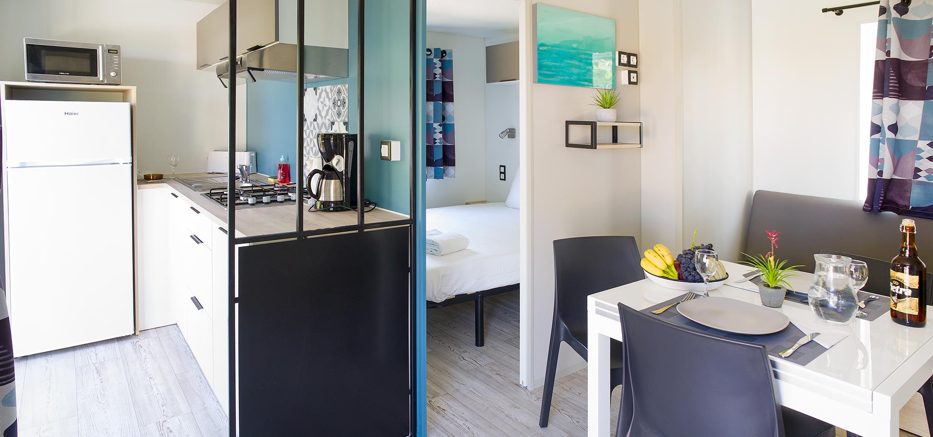 Camping san damiano bungalow luxe Capraia vue mer cuisine chambre principale coin salon repas table